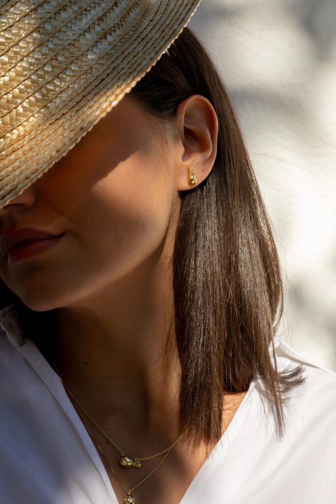 modelo con pendiente caracol oro y collares caracol en oro