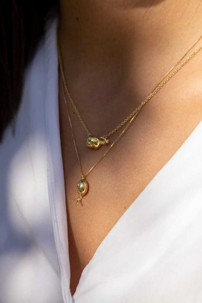 modelo con dos collares de caracol en oro