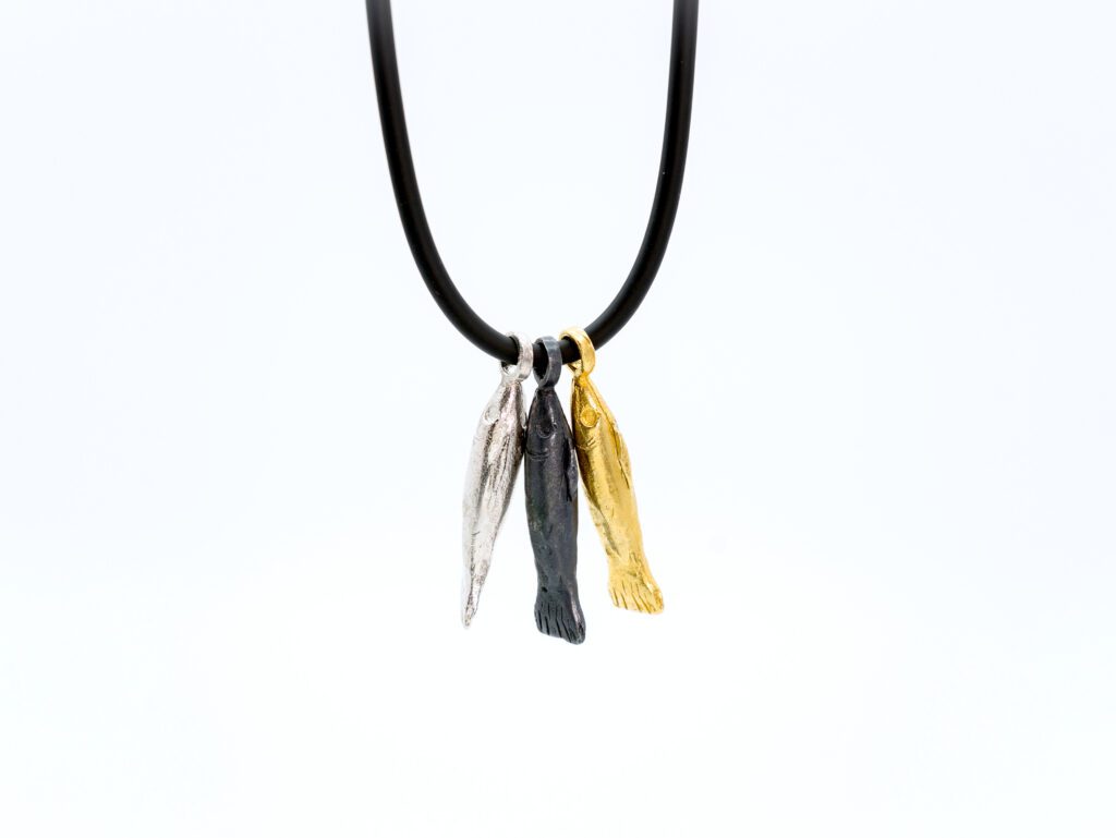 collar con tres colgantes de peces en oro, plata y plata black